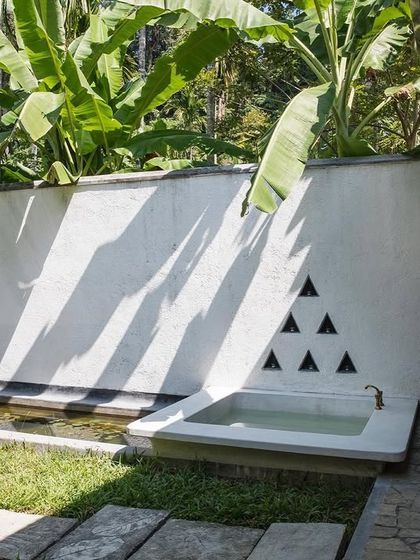 The private courtyard of the Garden Suite features an outdoor bathtub and a lily pond. This space offers a private sanctuary for guests to connect with nature, a core principle of biophilic residential design.