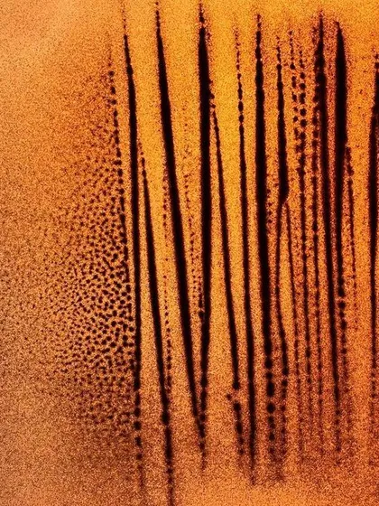 An untitled abstract work focusing on vertical lines and texture. The interplay between the fine, dotted sand and the stark black lines creates a sense of rhythm and depth.