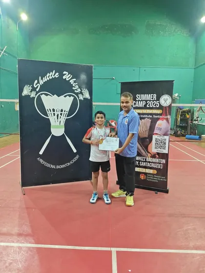 A young boy from our Santacruz East camp receives his medal and certificate. Our coaches provide personalized attention to help every child improve their game.