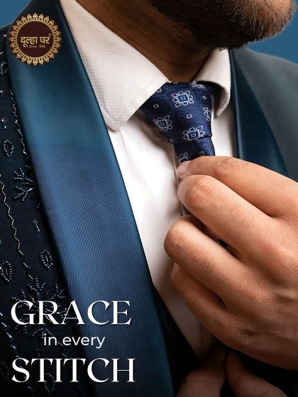 Grace in every stitch. A detailed shot of a navy suit, focusing on the patterned tie and satin lapel.