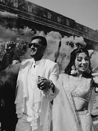 A black and white shot of a couple's entry with smoke bombs, adding a touch of drama and style.
