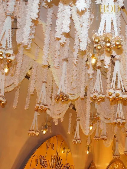 Another detail of the hanging floral chandeliers, with the light catching the golden bells and creating a warm, sparkling effect.