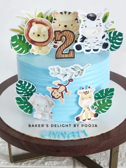 A small but mighty jungle-themed cake, perfect for an intimate party. This design features cute animal toppers and lush green leaves.