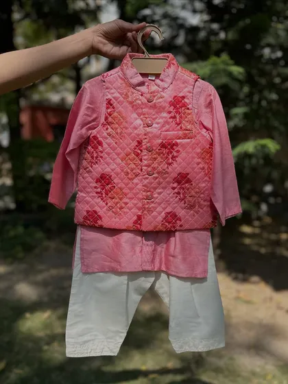 This boys' kurta set features a quilted Nehru jacket with a floral print. I offer this style in both pink and a soft beige.