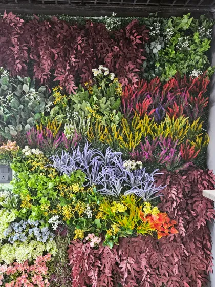 For a burst of color that lasts forever, I design dense, multi-textured artificial green walls. This close-up shows the variety of foliage I use to create a rich, maintenance-free landscape on any interior or exterior wall.
