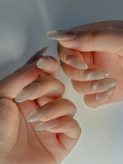 A subtle and ethereal nude cat-eye effect on long, stiletto-shaped nails. The finish is pearlescent and incredibly chic.