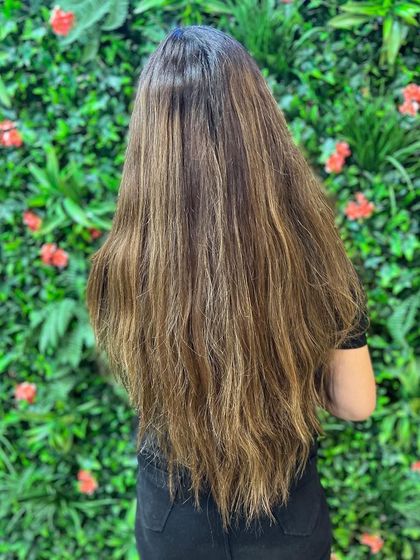 The before shot for a cool-toned transformation. The client started with long, warm-toned hair, ready for a fresh and modern update with cool hues.