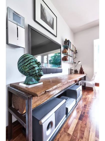 A detail of the custom media console in the Aishbagh study. We believe in integrating function with beautiful materials, and this piece combines a live-edge wood top with a sleek metal frame to house audio-visual equipment in a stylish, unobtrusive way.