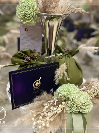 Another view of the bespoke invitation hamper for The Gourmet Fest, featuring a silver vase, custom potlis, and dried floral arrangements. We believe an invitation should be a gift in itself.