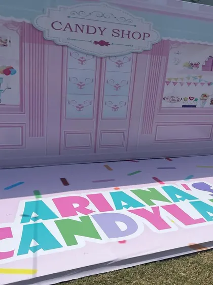 A sneak peek of a custom "Ariana's Candyland" photo booth backdrop before the party begins.