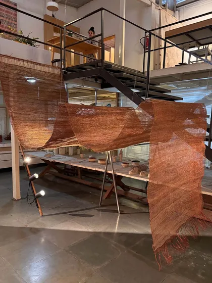 Our studio is a space of material alchemy. This image captures the process behind our 'Cu+Fibers' exhibition, a play of handspun and machine-made yarns. The journey of coaxing, manipulating, and responding to hemp, jute, and copper is a continuous engagement guided by the joy of small discoveries.