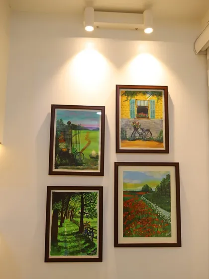 A personal art gallery created on a living room wall, with spotlights to highlight each piece. This is a wonderful way to showcase a client's personal collection.