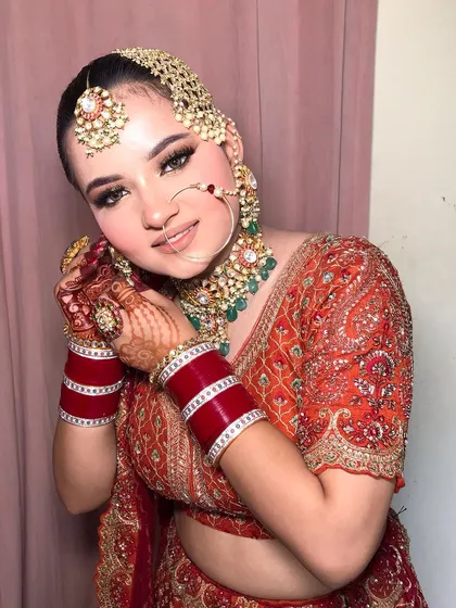 A playful pose showing the nath and the intricate details of her jewelry.
