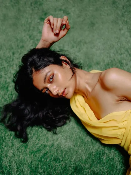 Another overhead shot on green turf from the yellow drape series. This angle offers a different perspective on the model's relaxed and peaceful pose.