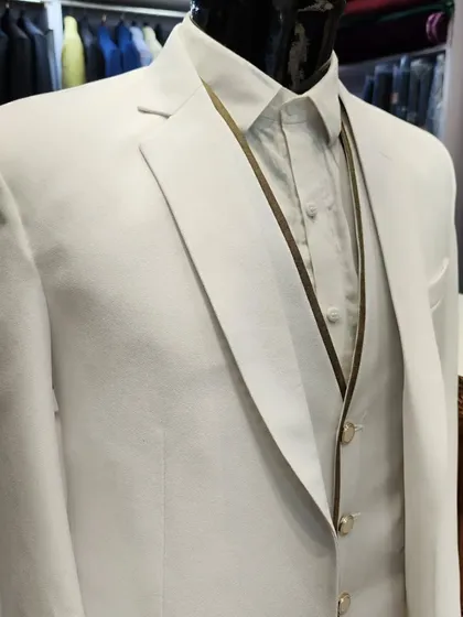 White suits are anything but boring when designed with the right details. This crisp white three-piece suit features subtle gold piping and buttons, offering a sharp and sophisticated look.