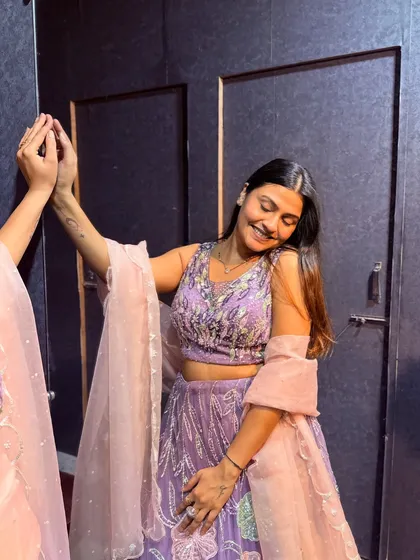 A candid moment of a client admiring her look in our lavender rental lehenga. It's all about feeling beautiful and confident.