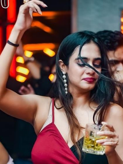 Wind in her hair, drink in her hand, lost in the music. A perfect party moment.