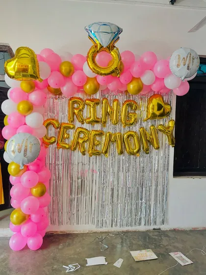 A bright and happy setup for a ring ceremony at home. I used a pink, white, and gold balloon arch against a silver tinsel curtain, with foil balloons to announce the special occasion.