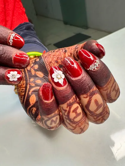 The perfect bridal nails to complement your mehndi. This classic red set is decorated with beautiful 3D flowers and a delicate line of stones for a look that is both traditional and stunning.