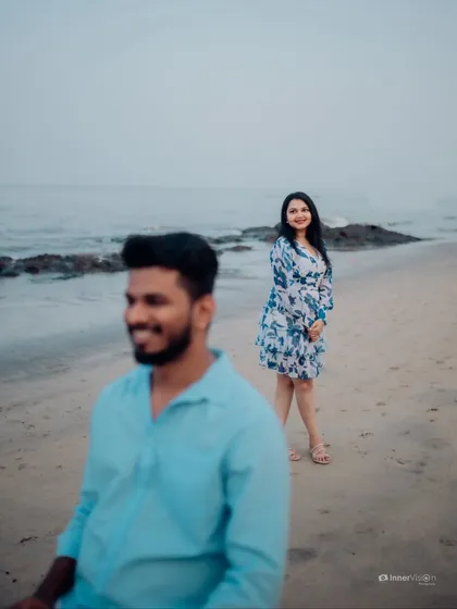 An artistic shot using depth of field to create a story. The focus is on the bride in the background, watching her partner with a smile, creating a sense of anticipation and love.