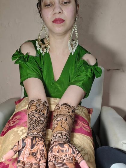 A client showcasing her beautiful Radha-Krishna and peacock themed mehendi.