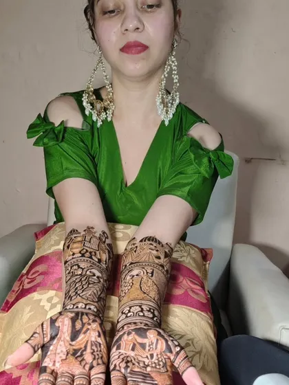 A client showcasing her beautiful Radha-Krishna and peacock themed mehendi.