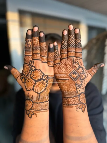 A stylish designer henna with a bold floral pattern on one hand and a geometric design on the other.