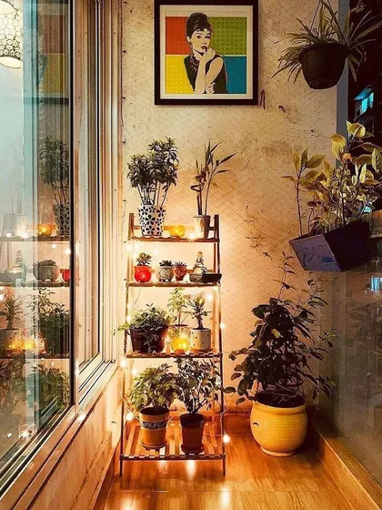 A simple plant shelf becomes a beautiful decor piece with the addition of delicate fairy lights. The warm light highlights the plants and adds a gentle, ambient glow to the balcony corner.