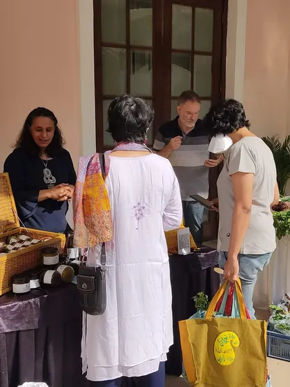 Customers interacting with a vendor selling homemade preserves.