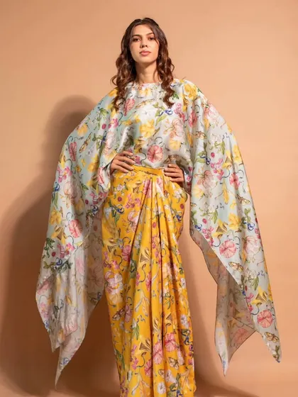 A full-length view of a stunning cape dress from Riddhi Jain Label, paired with soft, flowing hair and natural makeup.