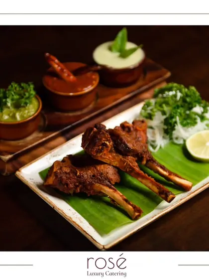 Succulent lamb chops marinated in spices and grilled to perfection. Served on a banana leaf with an assortment of chutneys, this dish showcases our mastery of authentic Indian flavors.