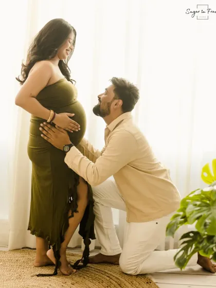 A beautiful pose where the dad-to-be kneels to look up at his wife and her baby bump, creating a powerful image of adoration and excitement.