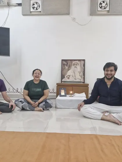 A small group smiles for a photo after a Surya Kriya session. The practice brings a sense of balance and joy, which is evident on their faces.
