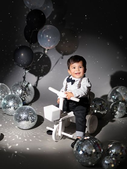 This little gentleman looks so dapper on his white tricycle, surrounded by sparkling disco balls. It's a unique and fun theme for a birthday celebration.