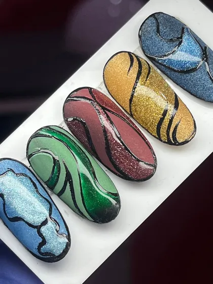 A set of five different glittery cat-eye nails, each with a unique abstract black line design, showing the versatility of the effect.