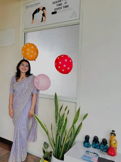 Posing by the entrance of our Bangalore studio during our second-anniversary celebration. The quote on the window, "Yoga doesn't take time, it gives time," is a philosophy I truly believe in.