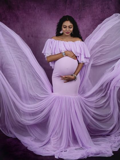 Angelic in lavender. The flowing fabric of this off-shoulder gown creates a beautiful wing-like effect, adding a touch of ethereal grace to this pregnancy photo.