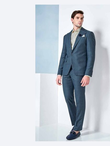 Every gentleman has a love affair with a well-tailored suit. This teal two-piece suit, crafted from fine fabrics, is a testament to that timeless relationship.