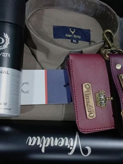 A stylish hamper with a brown Allen Solly shirt, a personalized wallet and keychain, and a name-engraved flask.