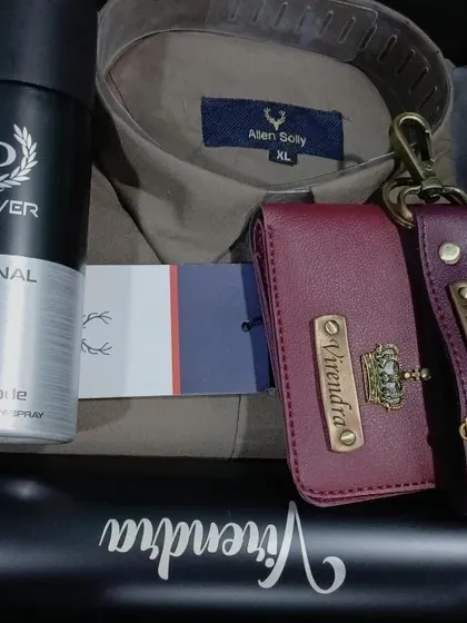 A sophisticated gift set with a personalized wallet and keychain, a name-engraved bottle, a shirt, and deodorant.