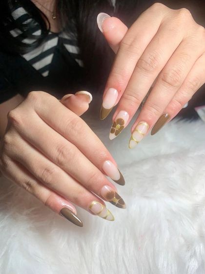 A stylish design with a brown French tip and accent nails featuring a floral pattern on a sheer base.