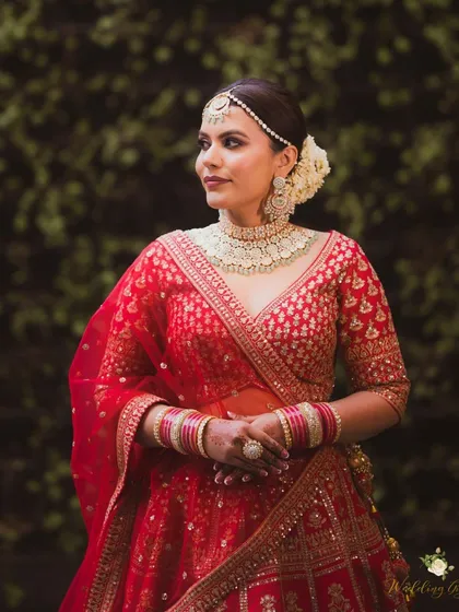 A beautiful portrait of the bride against a natural backdrop. Her makeup is luminous and her features are softly defined, creating a timeless and regal look.