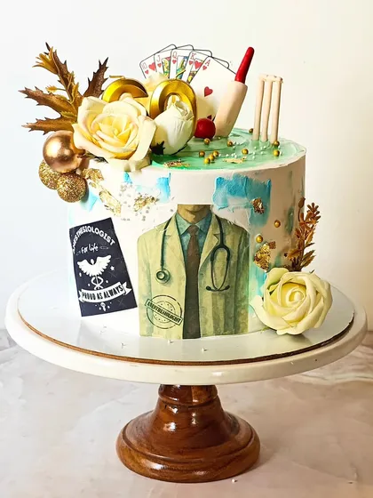 A personalized 60th birthday cake for a doctor who loves cricket and cards. The design incorporates all his favorite things, from a stethoscope and medical coat to a cricket bat and playing cards.