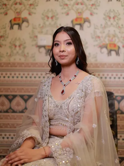 A portrait of the bride in her ivory gown. The soft shimmer on her eyes and glossy lips create a look of timeless charm.
