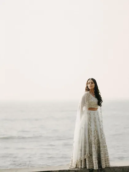 A serene portrait of the bride standing by the ocean. The vastness of the sea and sky creates a minimalist and powerful backdrop for this beautiful shot.