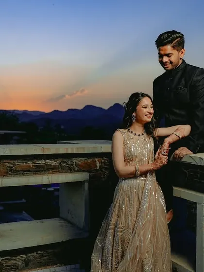 A breathtaking sunset shot from a rooftop in Udaipur, with the couple sharing a moment as the sky turns into a beautiful canvas of colors.