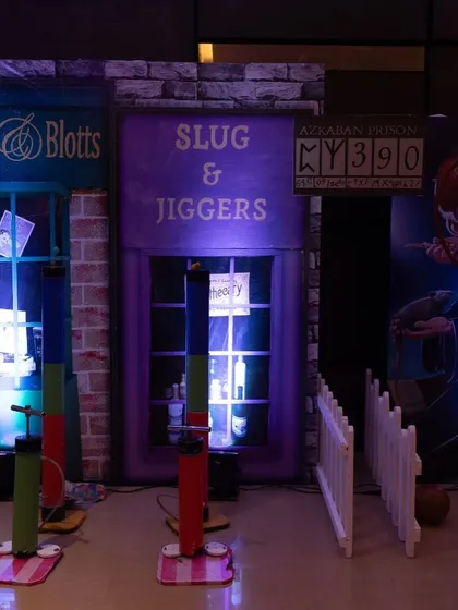 A game area inspired by Diagon Alley, featuring shops like Flourish & Blotts and Slug & Jiggers, with interactive games for guests.