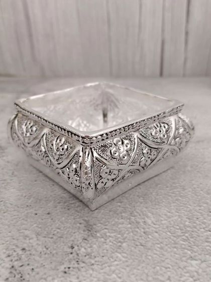 A square-shaped German silver urli with antique carving. This is a unique shape for an urli and looks very elegant.