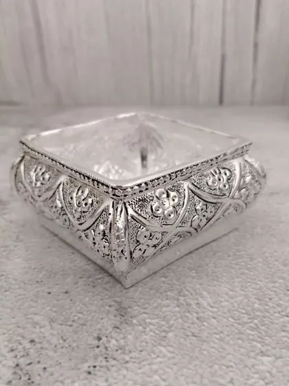 A unique square-shaped German silver urli with an antique finish, a modern take on a traditional item.