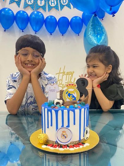 A Real Madrid drip cake being enjoyed by two young fans. It's always a joy to see my cakes bring smiles to faces.